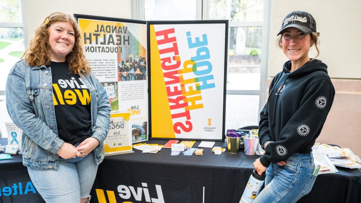 两个伊利诺伊大学的学生站在桌子前展示.